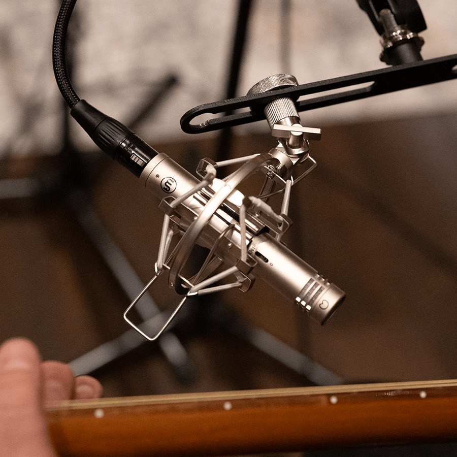 Warm Audio WA-84 small-diaphragm condenser, one of two permanent overhead pairs above the DW kit